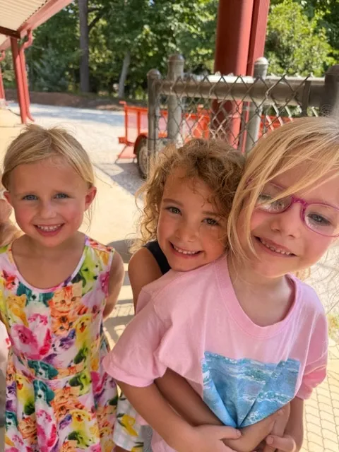 Three smiling girls outdoors