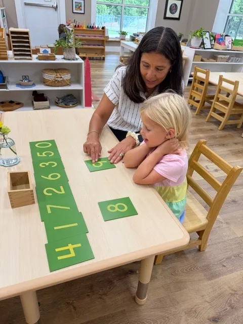 Teacher giving a lesson with large number cards