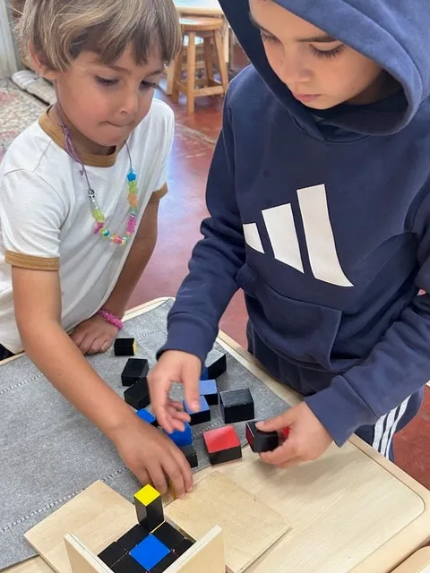Two children building the trinomial cube together
